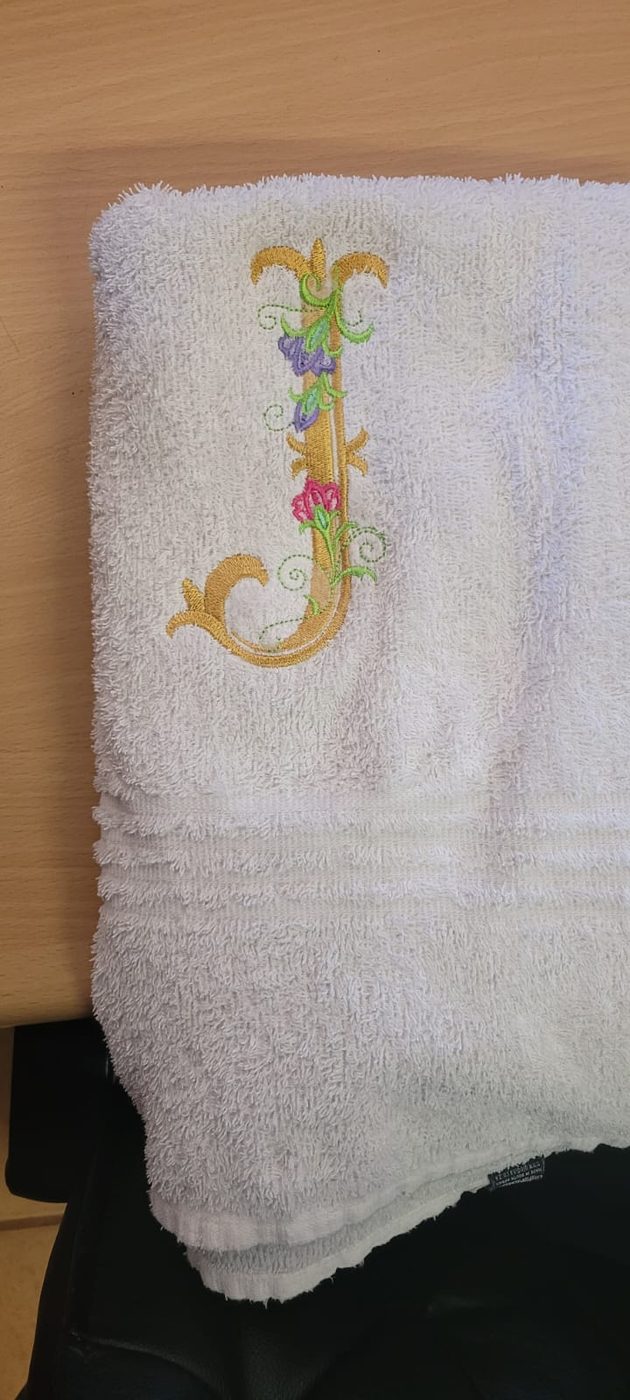 Elegant monogram letter embroidered on a towel by JJ Embroidery Services